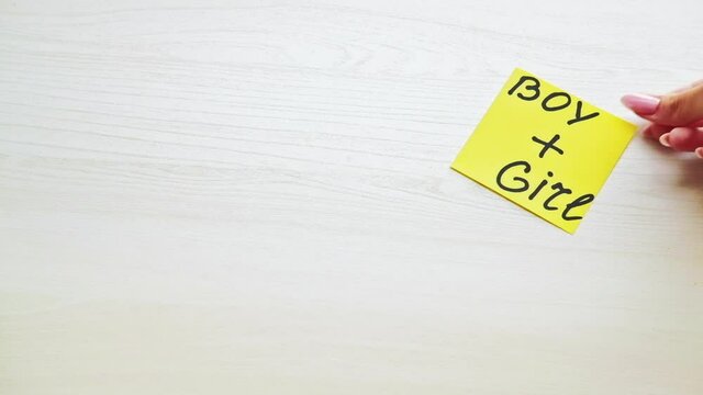 Sign mark. Gender relationship. Conceptual love. Happy notes. Yellow paper with inscription boy plus girl on white wooden table copy space.