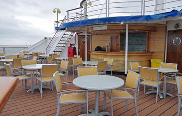 Outdoor sun and pool deck with dated rattan design patio terrace furniture, sun loungers and deck...