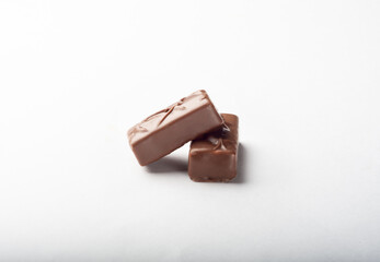 Two candies with milk chocolate on a white background for isolation. Sweets for tea.