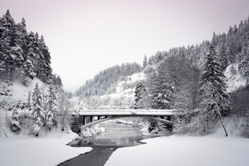 old historical bridge ulrichsbrücke over the river lech in musau in snowy winter