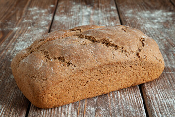 Freshly baked bread with white flour on a rustic wooden background. Healthy food. Concept of homemade bread