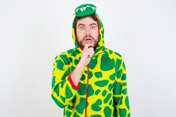 Fototapeta premium Nervous puzzled Young caucasian man wearing a pajama standing against white background opens mouth from surprise, reacts on sudden news.