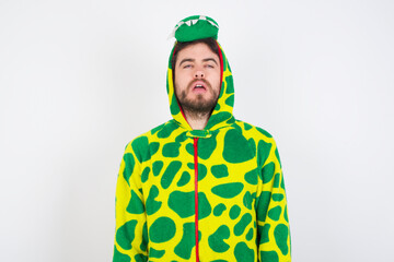 Fototapeta premium Young caucasian man wearing a pajama standing against white background looking sleepy and tired, exhausted for fatigue and hangover, lazy eyes in the morning.