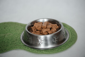 wet cat food, dogs on a light background, on the green carpet delicious cat food