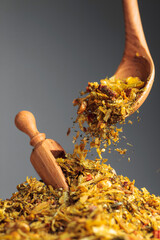 Mixtures of various spices are poured with a wooden spoon.