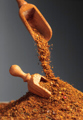 Mixtures of various spices are poured with a wooden spoon.