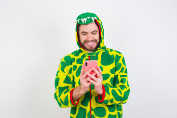 Young caucasian man wearing a pajama standing against white background using mobile phone chatting free time .