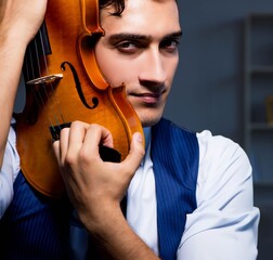 Young musician man practicing playing violin at home