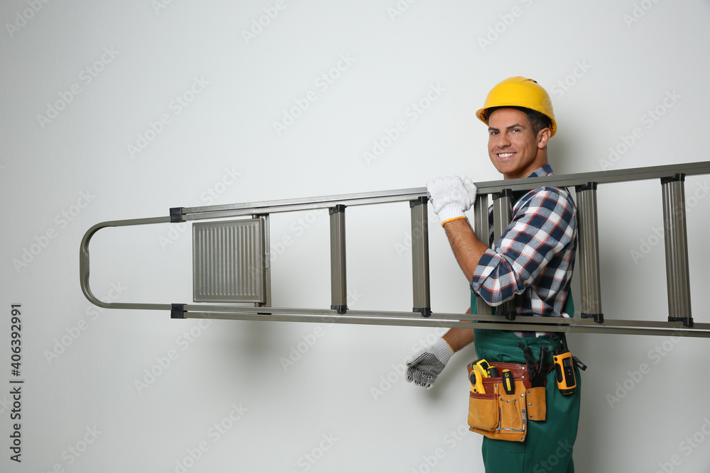 Poster Professional builder carrying metal ladder on light background