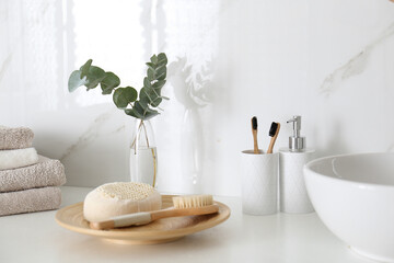 Fresh eucalyptus branches and bathroom items on countertop