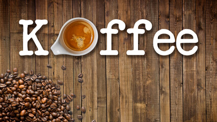 Eine Tasse Kaffee auf Holz von oben mit Kaffeebohnen und Schrift