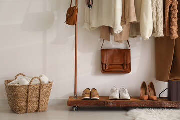Fototapeta na wymiar Rack with stylish shoes and women's clothes in dressing room. Modern interior design