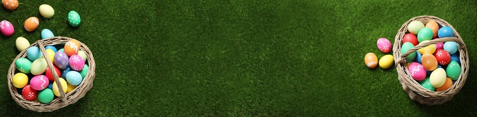 Flat lay composition with colorful Easter eggs on green grass, space for text. Horizontal banner design