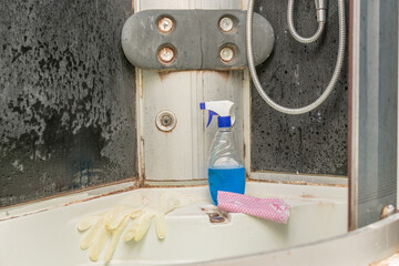 a bottle of detergent, gloves and a rag stand in the shower close-up. Terrible, unpleasant, very dirty bathroom. Concept - We will remove any dirt, even old curly, mold and mildew. Klinig.