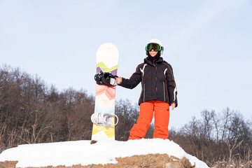 senior woman in red and blacksports wear with snowboard