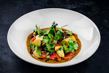 Top view of seared salmon with avocado in bowl, seared salmon salad with sauce at a premium restaurant