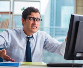 Fototapeta premium Unhappy businessman sitting at desk in office
