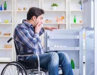 Young disabled injured man opening the fridge door