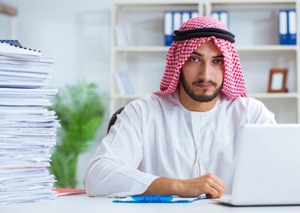 Arab businessman working in the office doing paperwork with a pi