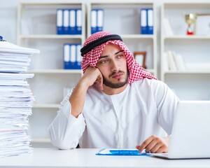 Arab businessman working in the office doing paperwork with a pi