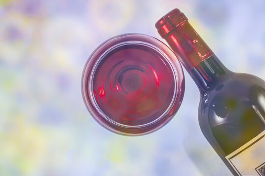 
Bottle and glass of red wine. Pastel image.