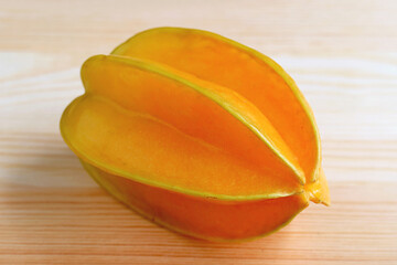 Closeup Fresh Ripe Vibrant Orange Yellow Starfruit Isolated on Wooden Background