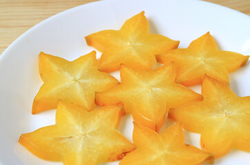 Slices of Juicy Fresh Ripe Starfruit on White Plate