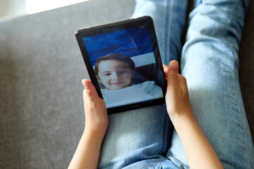 Little child girl at home talk video with tablet meeting, online call friend