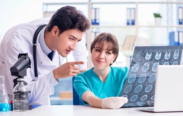 Obraz premium Two doctors discussing x-ray MRI image in hospital