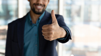 Crop close up of smiling African American businessman show thumb up recommend good quality service. Happy ethnic man give recommendation to company or training course. Employment concept.