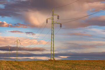 Power line and field at sunset sky. Autumn landscape.