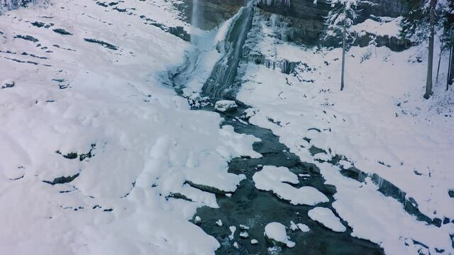 A Close up Aerial View of the Cascade du Rouget covered in snow during winter, French Alps