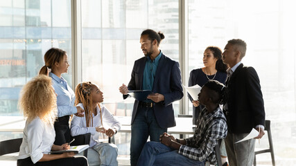 Diverse multiethnic businesspeople gather at casual meeting in office, brainstorm over business...
