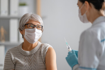 Doctor giving a senior woman vaccination