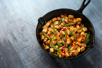 Vegetarian meat free mycoprotein pieces vegetable stir fry served in cast iron skillet frying pan