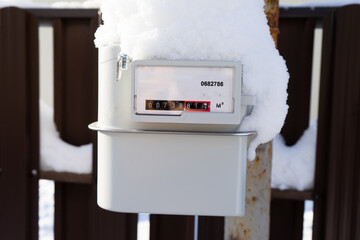the gas meter is covered with snow and frost. frozen outdoor gas meter.