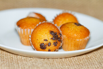 Mini muffins with chocolate on the white plate, selective focus