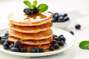 Homemade American pancakes with blueberry and golden honey. Healthy morning breakfast