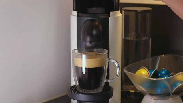 Close up view of end of brewing process of coffee. Emptying of capsule from Nescafe machine.