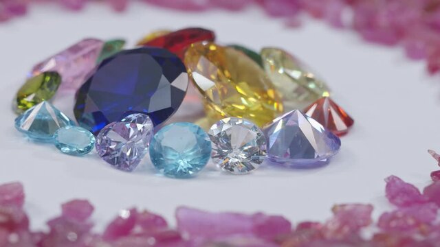 colorful diamonds of various sizes are placed in a center circle on a white background surrounded by white diamonds 
 and spinning around.

