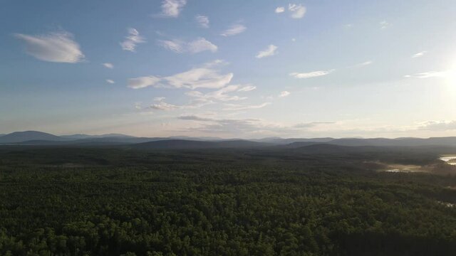 Aerial view rotating and overlooking stunning Mount Katahdin, blue lakes and green scenery during golden hour in Maine Baxter State Park, Appalachian Trail, USA.
