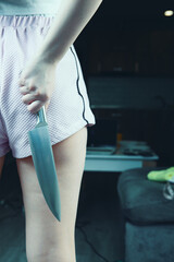 girl holding a kitchen knife to protect herself