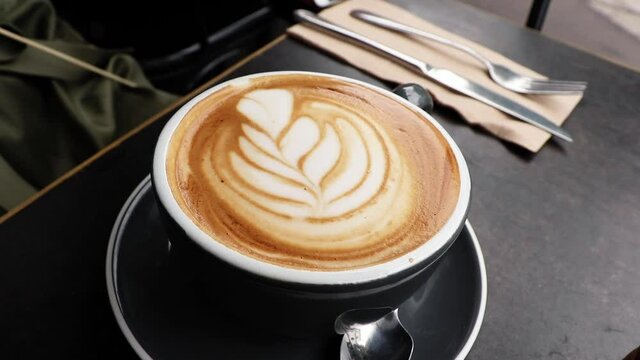 Latte art of tulip in coffee shop for breakfast in Australia with a black mug. The coffee art in Australia was great and the lattes were delicious.