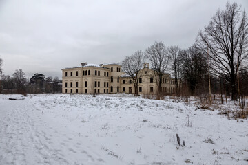 Fototapeta na wymiar A beautiful old abandoned manor. Winter day with snow. Ancient architecture of the building. 