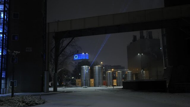 Beautiful laser beam projecting something on industrial urban buildings on a winter day with fresh snow on the ground