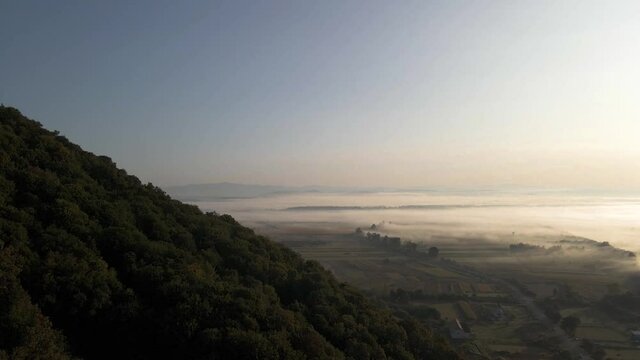Mist covering vast beautiful landscape in Ukrainian flatlands. Aerial.