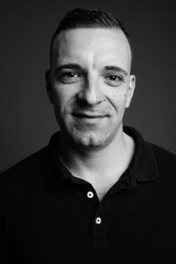 Man wearing black shirt against gray background