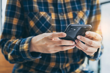 man work using cell phone hand holding mobile texting message contact us.chatting,search internet information in office.technology device communication connecting