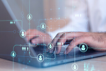 Hands of hr specialist is typing the keyboard in the internet to find the best candidates to create international network in recruitment process. Formal wear. Social media hologram icons.