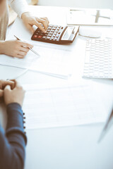 Accountant checking financial statement or counting by calculator income for tax form, hands...